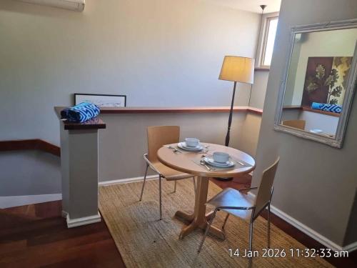 a room with a table and chairs and a mirror at Angel Apartment in Perth