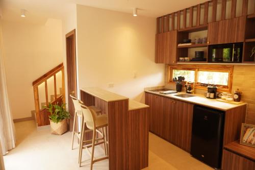 a kitchen with wooden cabinets and a counter top at Hermosa casita frente al mar en San Jose - Olon in San José