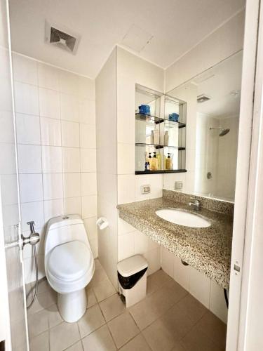 a white bathroom with a toilet and a sink at THE PRECIOUS TIME LOUNGe in Davao City