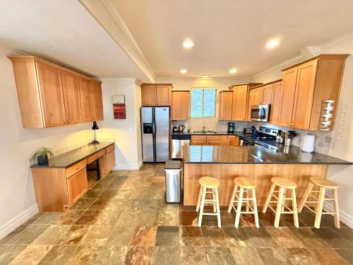 a large kitchen with wooden cabinets and bar stools at Spacious Townhome Near Downtown in Salt Lake City