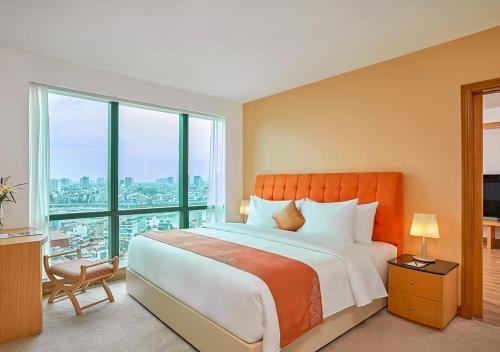 a bedroom with a large bed and a large window at Fortuna Hotel Hanoi in Hanoi