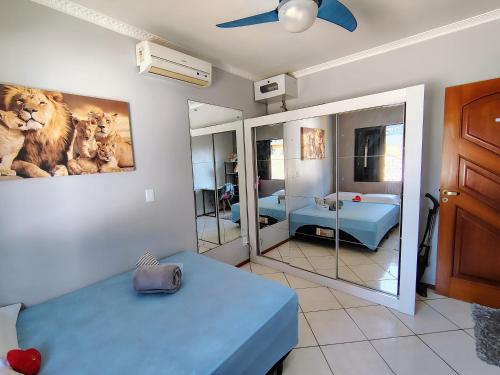 a bedroom with a blue bed and a mirror at Sobrado 4 quartos com piscina praia do tabuleiro in Barra Velha