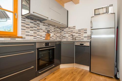 a kitchen with a stainless steel refrigerator and cabinets at Brunarica Murka in Bohinj