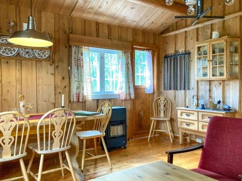 a kitchen with wooden walls and a table and chairs at Simple Mountain Cabin Near Vinstra in Vinstra