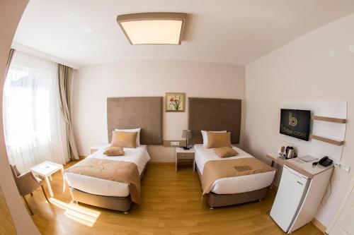 a hotel room with two beds and a television at Bilge Suite Hotel in Corum