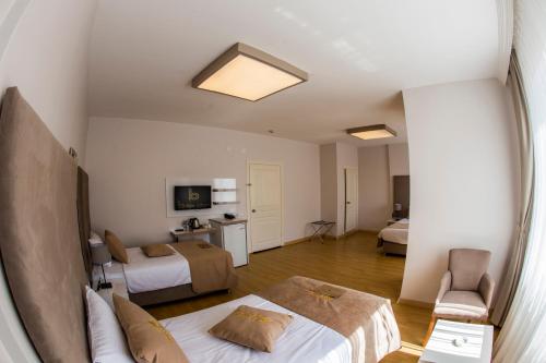 Habitación de hotel con 2 camas y sofá en Bilge Suite Hotel, en Corum