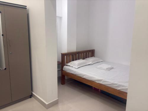 a small bedroom with a bed and a closet at Eiffel Pondy in Pondicherry