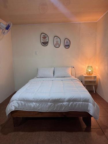 a bed in a bedroom with two plates on the wall at Magic Lodge - Cirrí, Naranjo in Cirrí