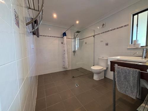 a bathroom with a shower and a toilet and a sink at Callala Beach Shack - Pet Friendly in Callala Beach