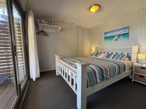 a bedroom with a bed and a window at Callala Beach Shack - Pet Friendly in Callala Beach