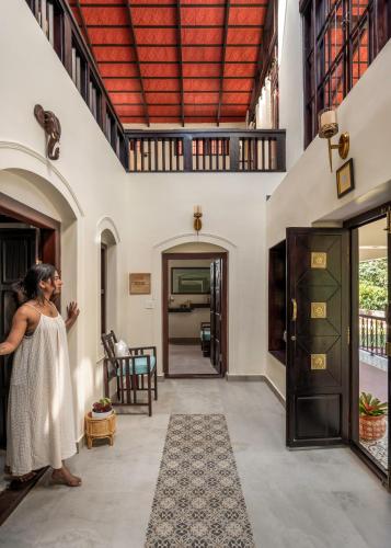 a woman standing in the hallway of a house at Kumberi Manor by Raho - Heritage Retreat in Coorg in Ammatti