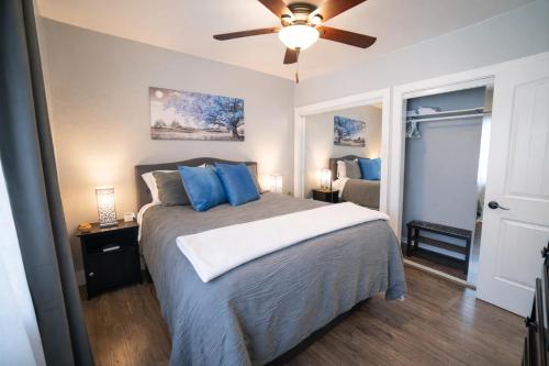 a bedroom with a bed with blue pillows and a ceiling fan at Aunt Beans Guest Suite in Kanab