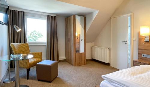 a hotel room with a bed and a table and chairs at Hotel Noltmann-Peters in Bad Rothenfelde