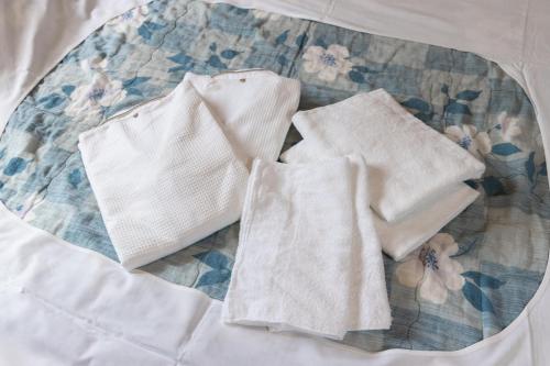 two white towels sitting on top of a bed at Hotel Daiki in Osaka