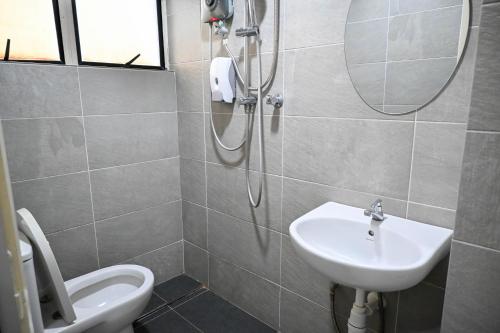 a bathroom with a sink and a toilet and a mirror at Pusat Belia Antarabangsa in Kuala Lumpur