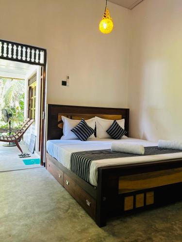 a bedroom with a large bed with blue and white pillows at Samson's Home in Hiriketiya