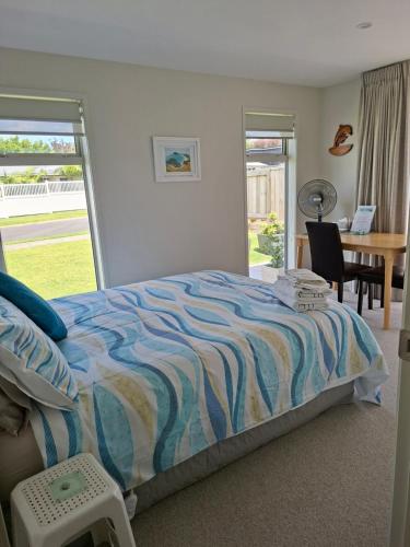 a bedroom with a bed and a table and a desk at Time n Tide in Athenree