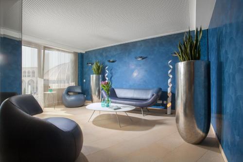 una sala de estar con paredes y sillas azules y una mesa. en Victory Gästehaus Therme Erding en Erding