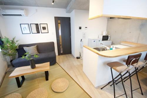 a living room with a couch and a kitchen at FelizLife 南馬込 201 in Tokyo