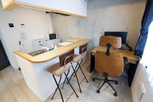 a kitchen with a counter and a sink and chairs at FelizLife 南馬込 201 in Tokyo