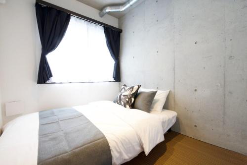 a bedroom with a large white bed with a window at FelizLife 南馬込 201 in Tokyo