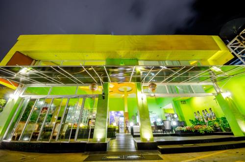 a building with a yellow and green facade at night at Anantra Pattaya Resort in Pattaya Central