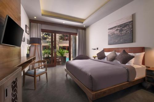 a bedroom with a large bed and a large window at Akana Boutique Hotel in Sanur