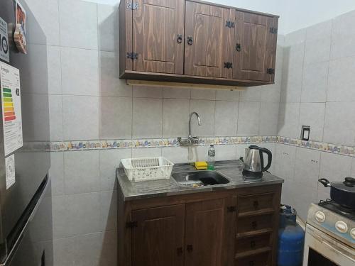 a kitchen with wooden cabinets and a sink at La vuelta y el vaso in Playa Verde