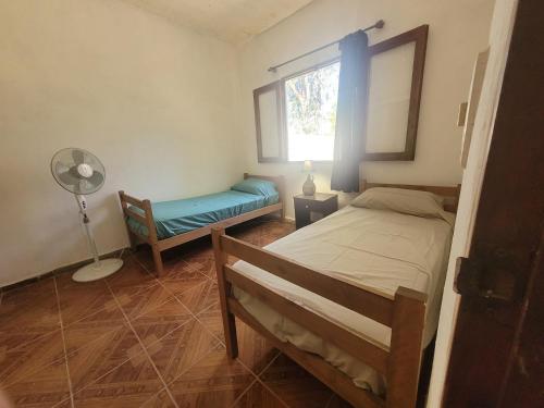 a bedroom with a bed and a window and a fan at La vuelta y el vaso in Playa Verde