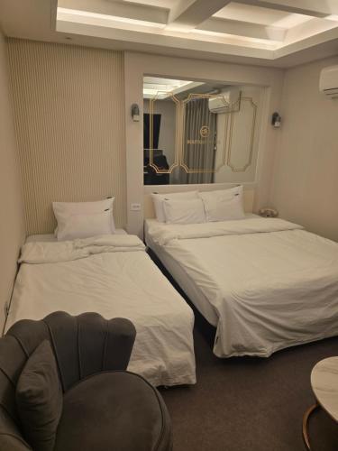 a hotel room with two beds and a chair at DK hotel in Incheon