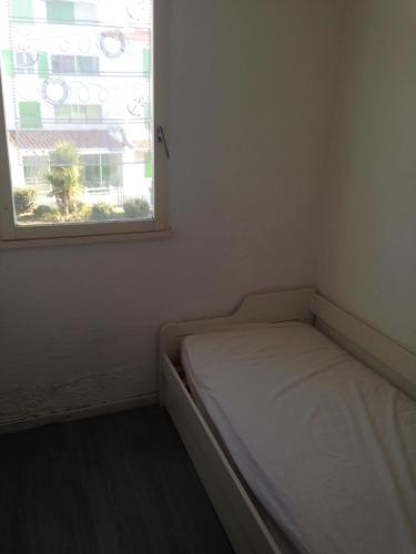 un petit lit dans une chambre avec une fenêtre dans l'établissement La Triere, à Saint-Hilaire-de-Riez