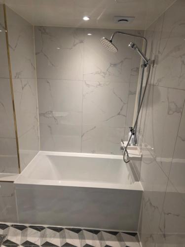 a white bath tub in a bathroom with a shower at DK hotel in Incheon