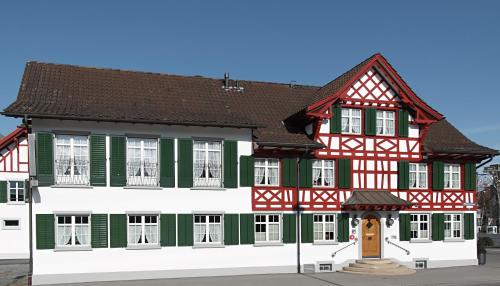 a building with red and green trim at Gasthof Eisenbahn in Weinfelden