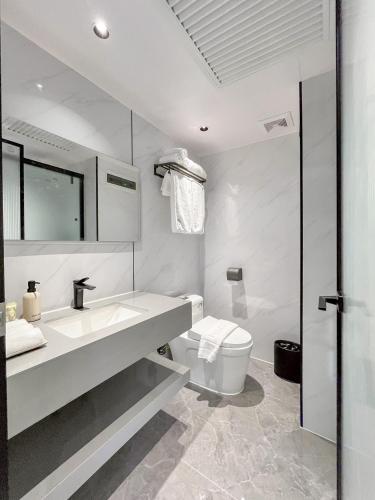 a white bathroom with a sink and a toilet at Mont Du Kwai Resort in Ban Yang (2)