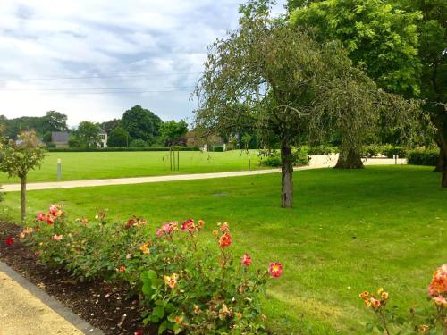 a park with trees and flowers in the grass at La Pommeraie in Bruz