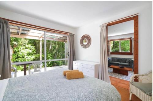 a bedroom with a bed and a large window at The Innlet, Country Apartments and Cottages in Collingwood