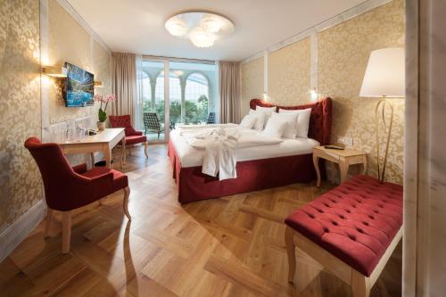 Schlafzimmer mit einem Bett, einem Schreibtisch und einem Stuhl in der Unterkunft Hotel Victory Therme Erding in Erding