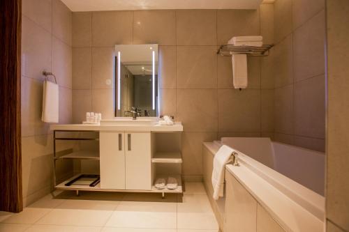 a bathroom with a sink and a bath tub at Radisson Blu Hotel & Residence Maputo in Maputo