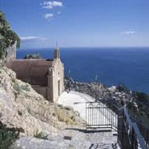 a building on the side of a mountain with the ocean at Hotel Panorama di Sicilia in Castelmola