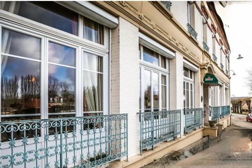 Le Renaissance في Montdidier: مبنى به نوافذ وشرفات في الشارع