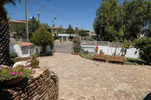 a courtyard with two benches and a fence at Hotel L'Aragosta in La Caletta