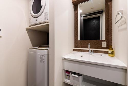 une salle de bains avec lavabo et micro-ondes dans l'établissement PORTO7-5, à Chatan