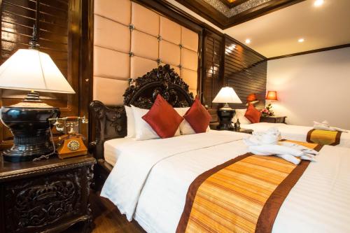 a bedroom with two beds with a stuffed animal laying on the bed at Villa Sirilanna Hotel in Chiang Mai