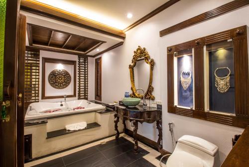 a bathroom with a tub and a sink and a toilet at Villa Sirilanna Hotel in Chiang Mai