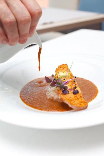 a person eating a piece of food on a plate at Hotel Alga in Calella de Palafrugell