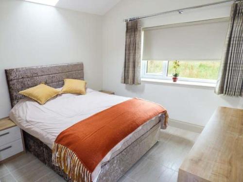 a bedroom with a large bed with a window at Shreyas Cottage in Blackburn