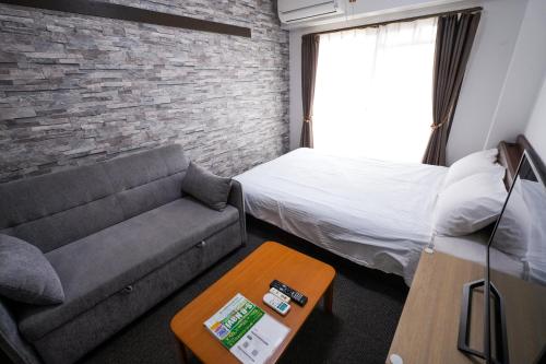 a living room with a couch and a brick wall at Cozy house 31, free wifi a rented electric bicycle in Kyoto