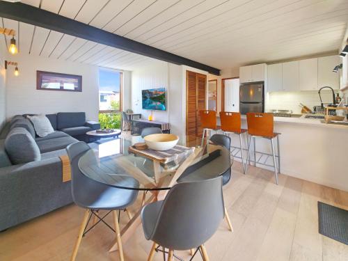 a kitchen and a living room with a table and chairs at The Hideaway - Lake Views I Ski & Bike Storage I Central Jindabyne I Free WiFi I BBQ I Parking in Jindabyne