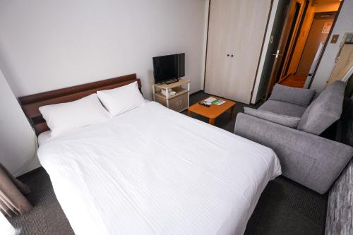 a hotel room with a bed and a chair at Cozy house 6, free wifi a rented electric bicycle in Kyoto