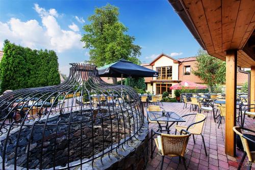 a bird cage with chairs and tables in a patio at Restaurace a Penzion U Palečků in Skuteč